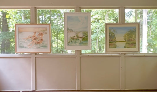 Three framed original watercolor paintings from Pamela Hallock's Georgian Bay Collection displayed together in a gallery setting with Turtle Bay on the right.