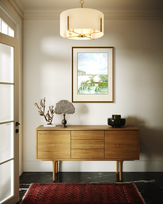 Framed Granite and Wind watercolor print of Georgian Bay shoreline displayed above a wooden console table in a modern interior.