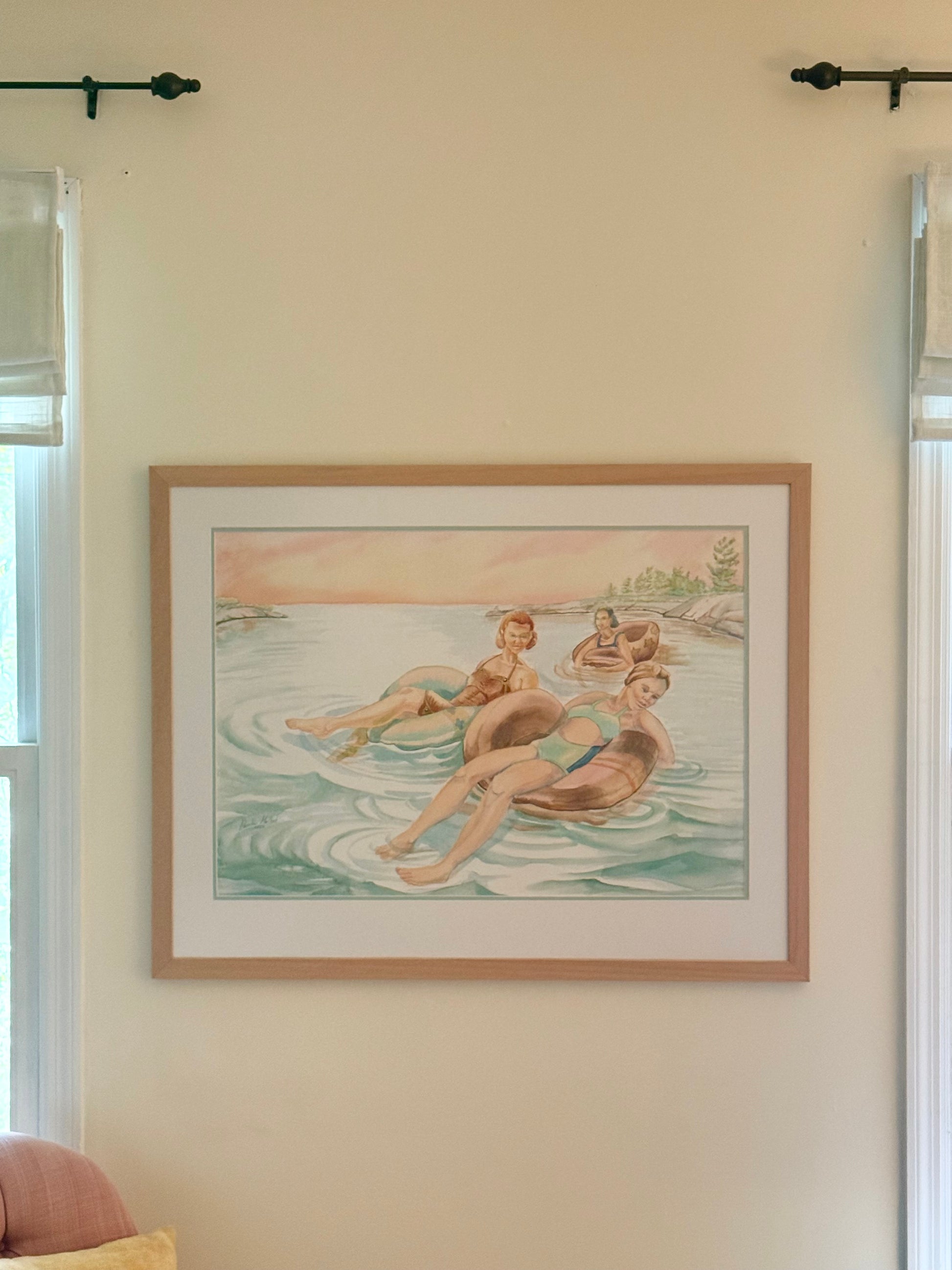 Framed original figurative watercolor "Pink Skies" by Pamela Hallock displayed on a living room wall, illustrating the artwork's scale and presentation in a home setting.