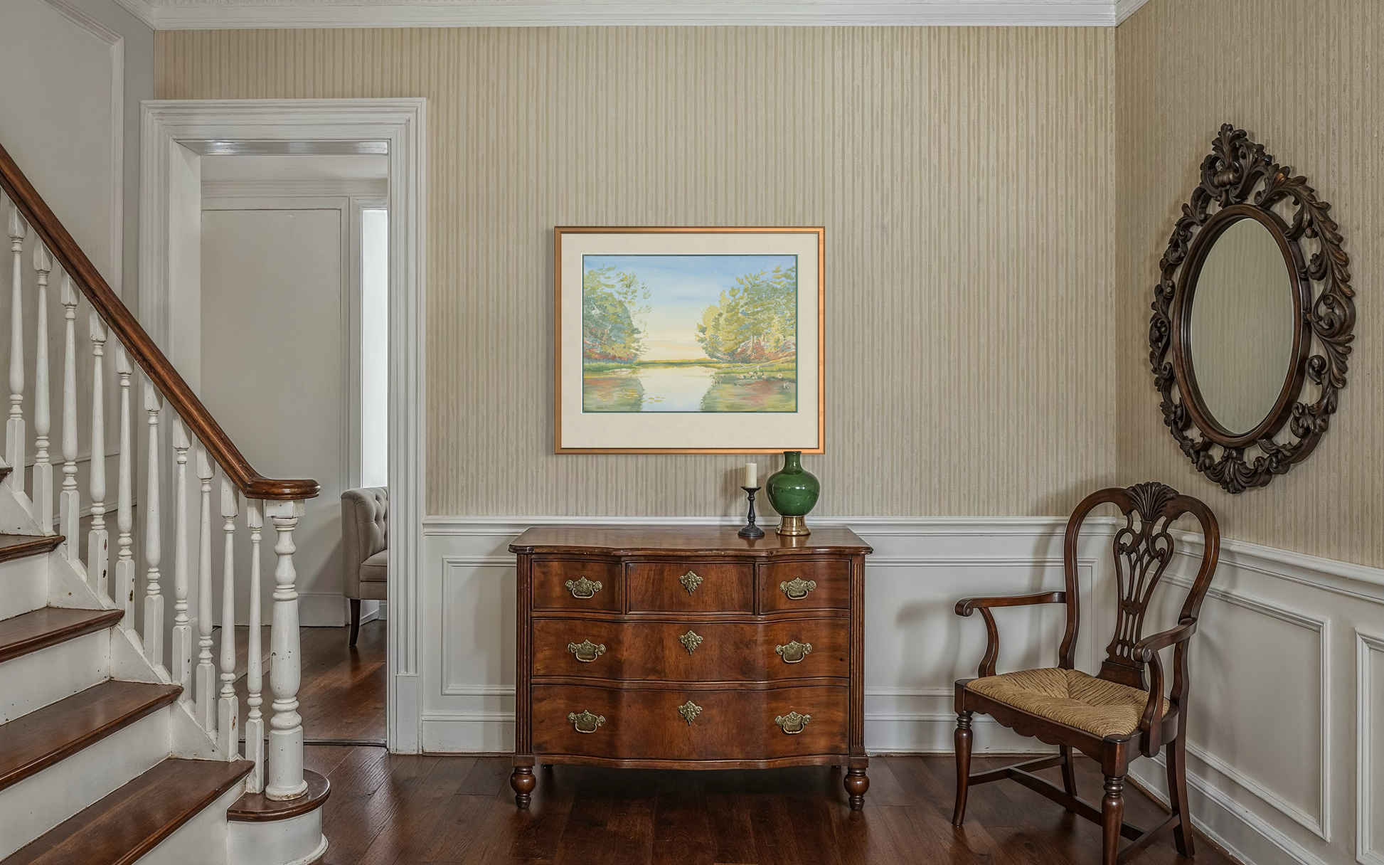 Framed Turtle Bay Georgian Bay sunrise watercolor print styled in a traditional home entryway with staircase and wood console table.