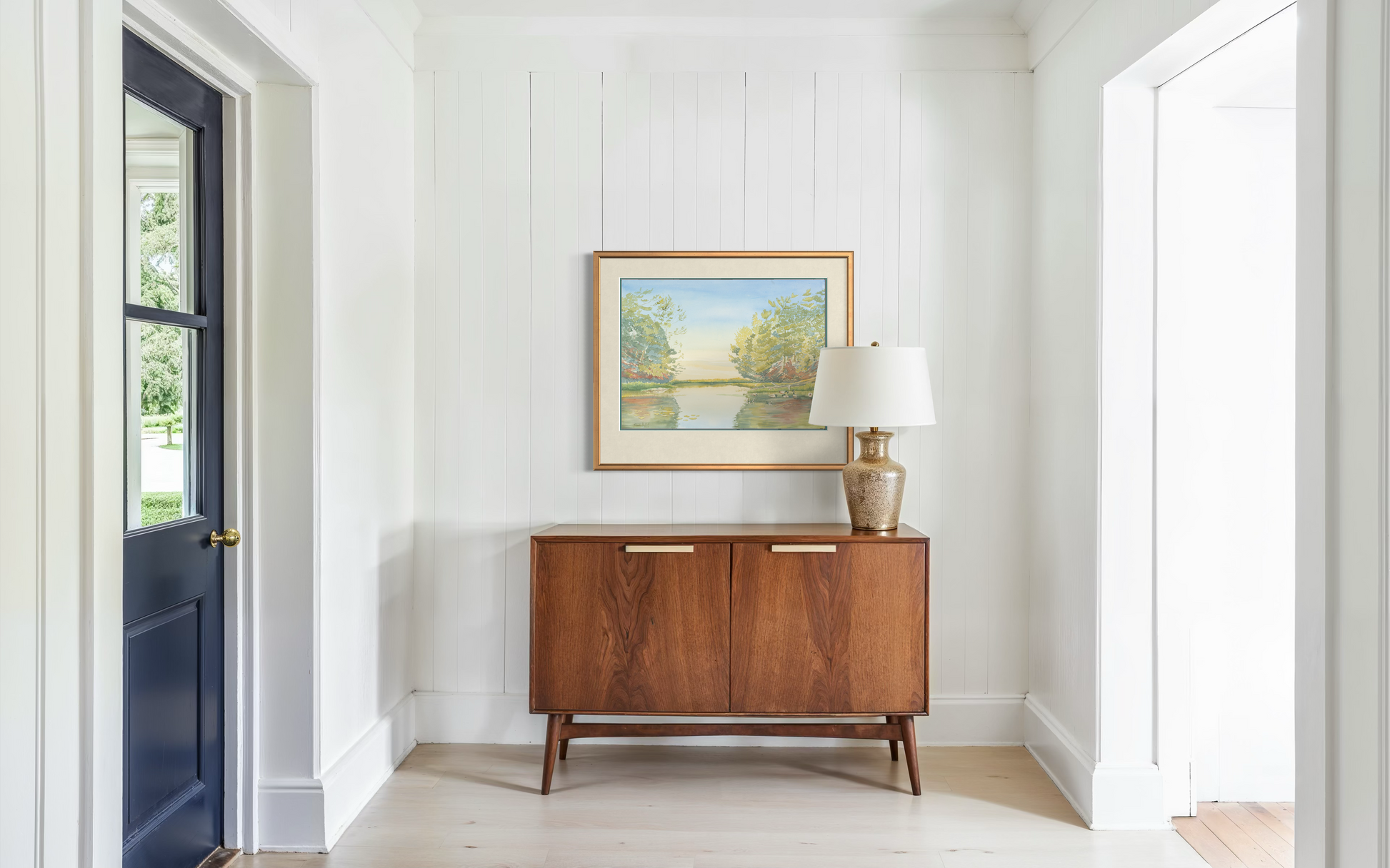 Turtle Bay Lake Huron landscape watercolor print framed and displayed in a bright minimalist hallway interior.