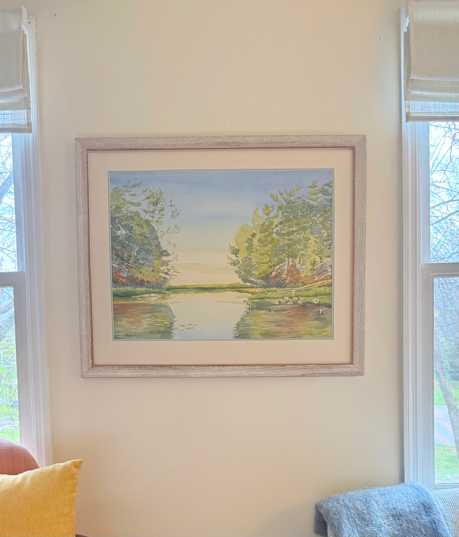 Framed original watercolor painting of Turtle Bay at sunrise, featuring calm blue water, white water lilies, pickerel weed, tall pines, and soft morning light inspired by Georgian Bay, Canada.